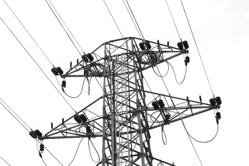 Electrical power lines at sunset with an energy meter in the foreground