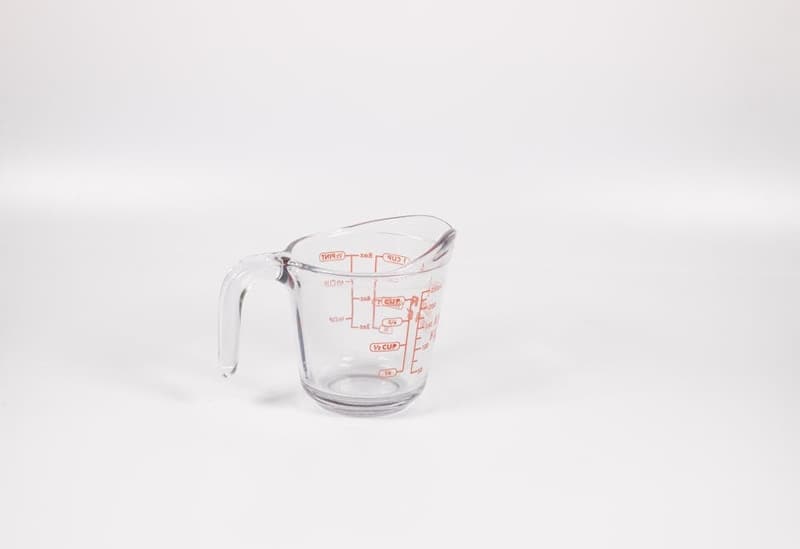 Measuring cups and spoons arranged on a kitchen counter with baking ingredients
