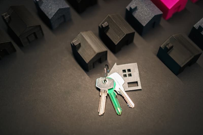 A couple reviewing mortgage documents at a desk with a small house model
